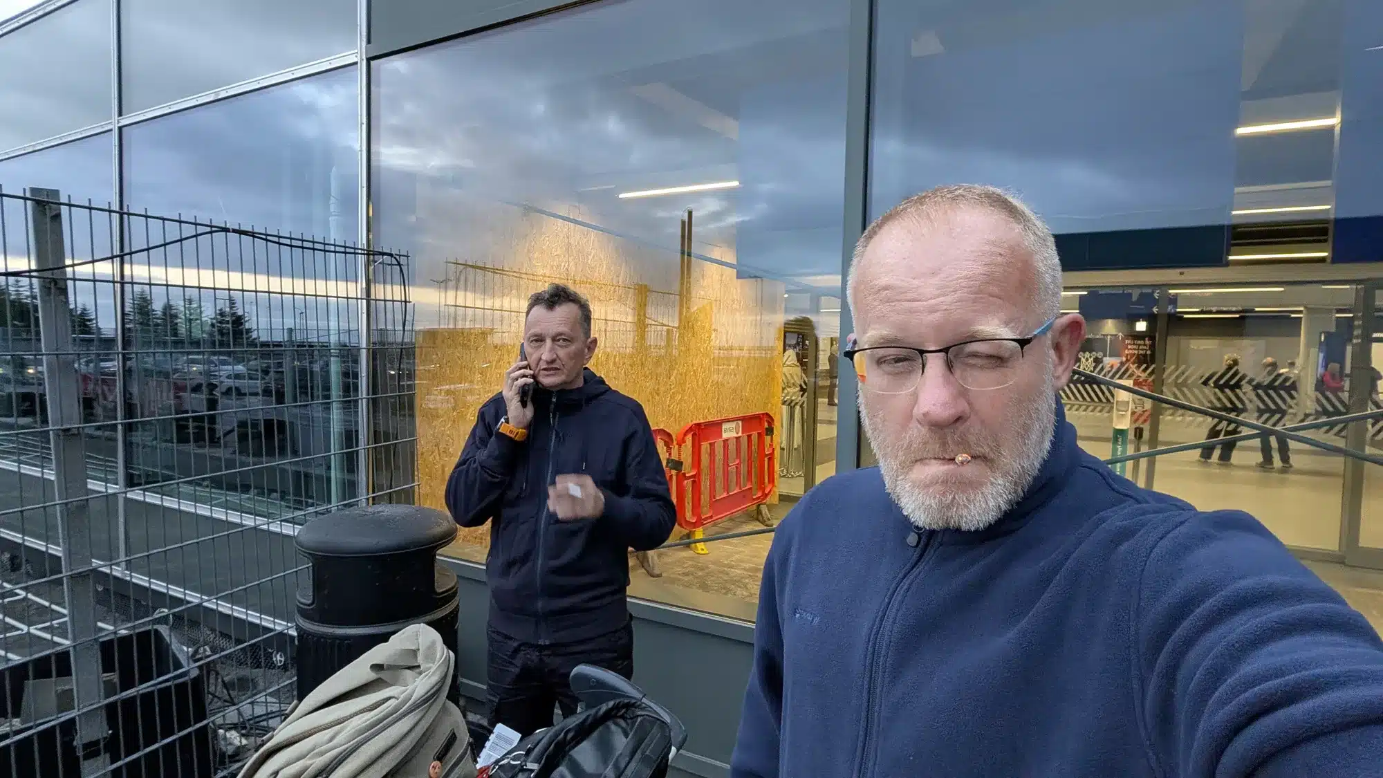 Two travellers in an airport terminal at dusk, setting off for Iceland