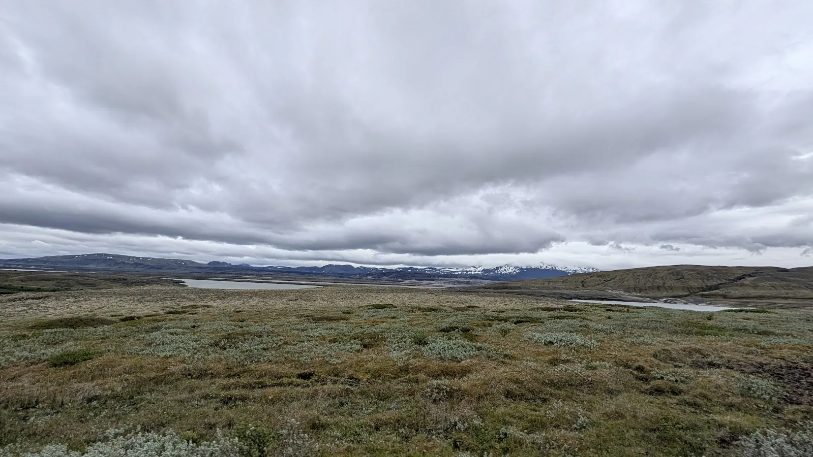 Wide green Icelandic highland moor under heavy grey clouds