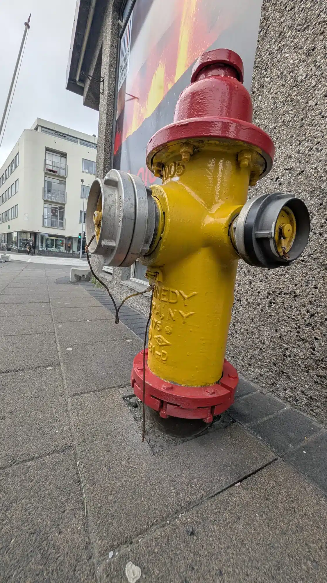 Red and yellow fire hydrant on a pavement in Iceland